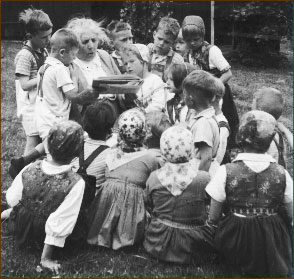 Photograph of Elsa Beskow, Swedish children's author and illustrator, reading to a large group of children